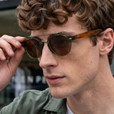 Homem Usando o Óculos Cannes Polarizado Verde com Lentes Marrons na Cidade