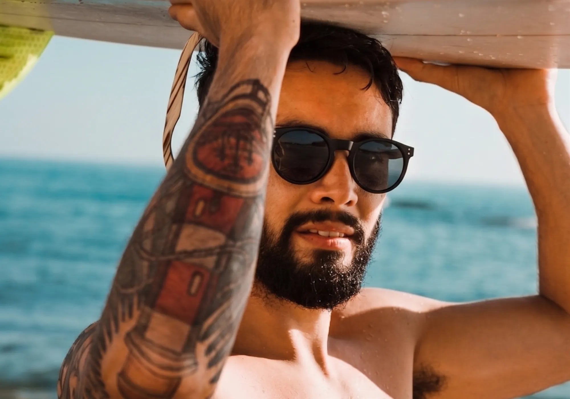 Homem usando óculos Reels Polarizado Pretona Praia com proteção UV400