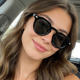 Modelo  Feminina Usando o Óculos Positano Preto com Lentes Cinzas