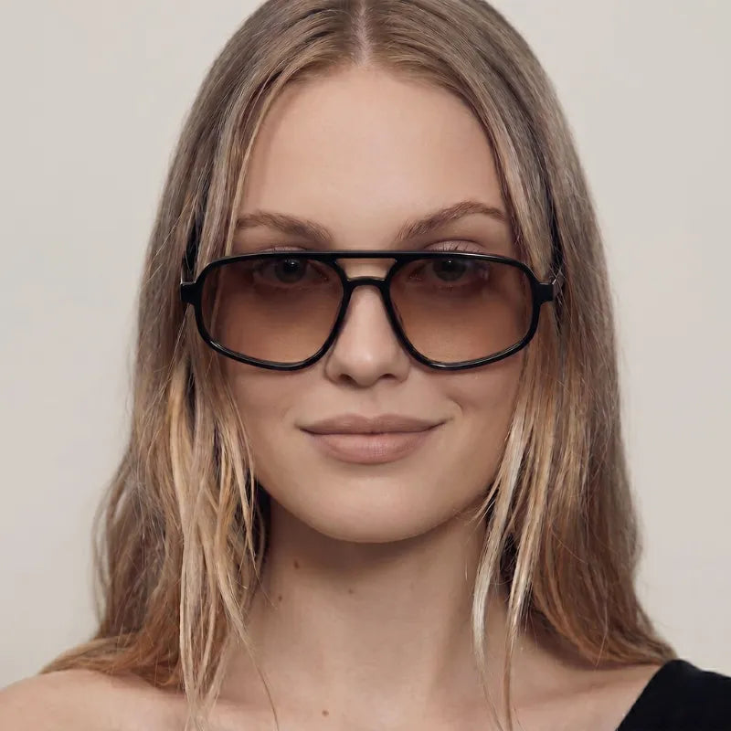 Mulher Usando o Óculos Essenza UV400 na Cor Preta com Lentes Marrons