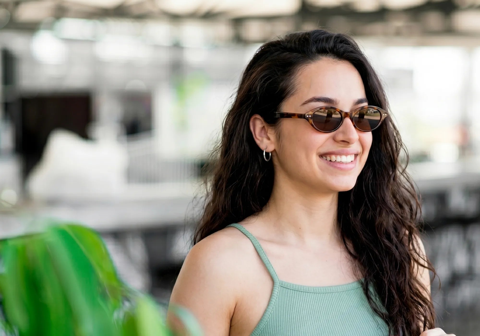 Mulher usando óculos Jeri Leopardo oval em ambiente externo com estilo leve e casual
