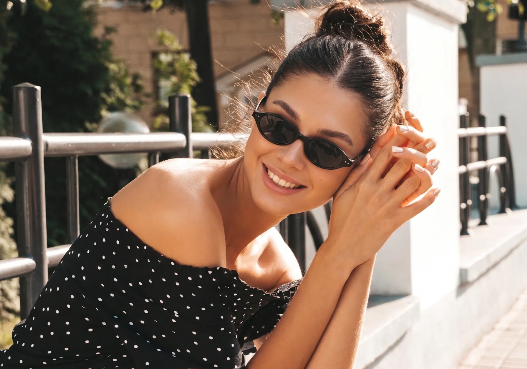 Mulher usando óculos Jeri preto oval em ambiente externo com estilo leve e casual