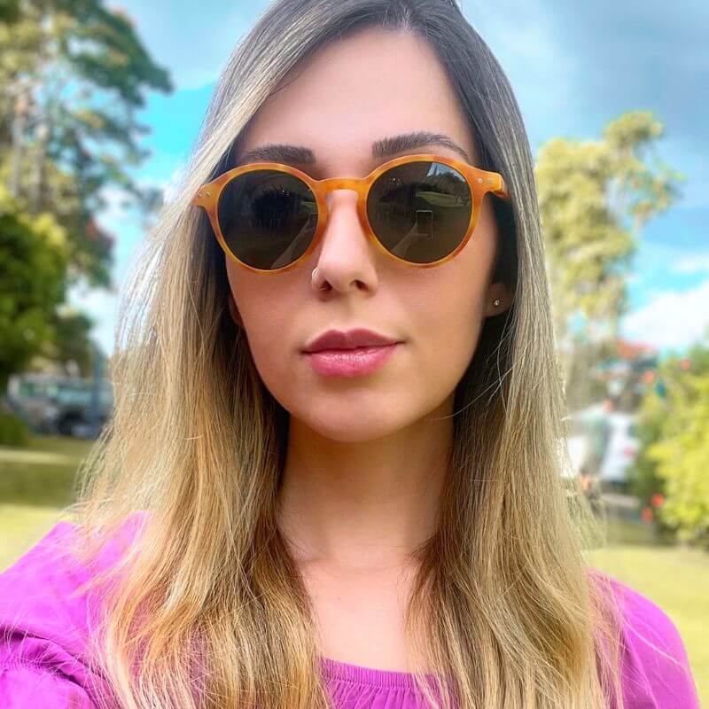 Mulher com Óculos Rio Polarizado laranja mesclado ao ar livre